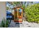 Outdoor sauna with glass door, adjacent to fence with paddleboards, surrounded by lush landscaping at 913 Tennessee Ln, Sarasota, FL 34234