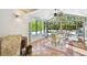 Bright sunroom with tile flooring, ceiling fan, and an abundance of natural light from large windows overlooking the pool at 913 Tennessee Ln, Sarasota, FL 34234