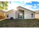 A backyard with a stucco home that includes a covered patio, windows, an AC unit, and sparse foliage at 12511 Lake Vista Dr, Gibsonton, FL 33534