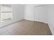 An empty bedroom featuring tile floors, a closet, and a window at 12511 Lake Vista Dr, Gibsonton, FL 33534