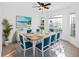 Inviting dining room with a light wood table, blue chairs, and bright natural light from multiple windows at 12511 Lake Vista Dr, Gibsonton, FL 33534