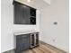 Stylish bar area with dark cabinets, quartz countertop, and stainless steel wine fridge at 8936 Sanders Tree Loop, Wesley Chapel, FL 33545