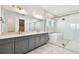 Bathroom boasts double vanities, a freestanding tub, a glass-enclosed shower, and upscale finishes at 8936 Sanders Tree Loop, Wesley Chapel, FL 33545