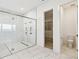Elegant bathroom features a glass-enclosed shower, stylish fixtures, and a convenient layout with access to a walk-in closet at 8936 Sanders Tree Loop, Wesley Chapel, FL 33545