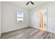 Bright bedroom with wood-look floors, white walls, and natural light at 8936 Sanders Tree Loop, Wesley Chapel, FL 33545