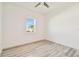 Bright bedroom with wood floors and a window view of the outside at 8936 Sanders Tree Loop, Wesley Chapel, FL 33545