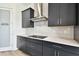 Modern kitchen showcasing sleek black cabinetry, stainless steel appliances, and a stylish range hood at 8936 Sanders Tree Loop, Wesley Chapel, FL 33545