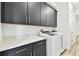 Well-organized laundry room with cabinets, countertops, and modern appliances at 8936 Sanders Tree Loop, Wesley Chapel, FL 33545