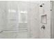 Marble-tiled walk-in shower with a glass door and bronze hardware at 8936 Sanders Tree Loop, Wesley Chapel, FL 33545