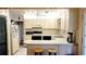 Well-lit kitchen with white cabinetry, tiled countertops, and breakfast bar seating at 6639 Renaldo S Way, St Petersburg, FL 33707
