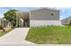 Well-maintained home with a covered parking area and a lush green lawn at 8857 Highpoint Blvd, Brooksville, FL 34613