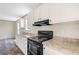 Modern kitchen featuring granite-look countertops, black appliances and sleek white cabinetry at 8857 Highpoint Blvd, Brooksville, FL 34613