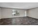 Bright living area features beautiful flooring, two windows, and a white door at 8857 Highpoint Blvd, Brooksville, FL 34613