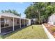 Landscaped backyard with a wooden fence, healthy grass, and screened-in porch at 754 Cape Cod Cir, Valrico, FL 33594