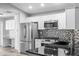 Bright kitchen features stainless appliances, granite counters, stylish backsplash, and ample white cabinetry at 754 Cape Cod Cir, Valrico, FL 33594