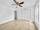 Bright bedroom with ceiling fan, tile floors, closet, and natural light from the window at 8608 Huron Ct # 57, Tampa, FL 33614