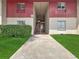 Exterior view of the two-story condo with landscaped walkway leading to the units at 8608 Huron Ct # 57, Tampa, FL 33614