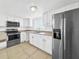 Kitchen features stainless steel appliances, white cabinets, and tile flooring at 8608 Huron Ct # 57, Tampa, FL 33614