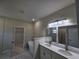 Bright bathroom featuring double sinks, marble floors, a soaking tub and open access to the closet at 2310 Logsdon St, North Port, FL 34287