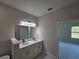Modern bathroom features a double vanity with white cabinets and countertop, with a neutral color palette at 2310 Logsdon St, North Port, FL 34287