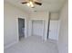 Bright bedroom with neutral paint, tile floors, ceiling fan, closet and access to the bathroom at 2310 Logsdon St, North Port, FL 34287
