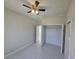 Bright bedroom with neutral paint, tile floors, ceiling fan, closet and access to the bathroom at 2310 Logsdon St, North Port, FL 34287