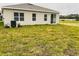 Home's backyard with a sliding glass door leading to a spacious area at 29307 Meadowcroft Ave, Wesley Chapel, FL 33544