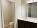 Bright bathroom featuring a single sink vanity, toilet, and tile floors at 29307 Meadowcroft Ave, Wesley Chapel, FL 33544