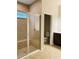 Bathroom featuring tile shower with glass door, and an adjoining toilet room at 29307 Meadowcroft Ave, Wesley Chapel, FL 33544