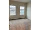 Bedroom featuring neutral walls, plush carpet, and two bright windows at 29307 Meadowcroft Ave, Wesley Chapel, FL 33544