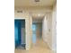 Bright hallway with tiled flooring leading to various rooms, showcasing open floor plan at 29307 Meadowcroft Ave, Wesley Chapel, FL 33544