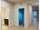 Hallway showcasing tile floors leading to a bathroom and carpeted bedroom at 29307 Meadowcroft Ave, Wesley Chapel, FL 33544