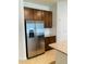 Kitchen featuring stainless steel refrigerator, dark cabinets and granite countertops at 29307 Meadowcroft Ave, Wesley Chapel, FL 33544