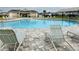 Community pool area with lounge chairs and covered seating area at 29307 Meadowcroft Ave, Wesley Chapel, FL 33544