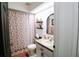 Bathroom featuring a tub with a shower, floral shower curtain, updated fixtures and decor at 4217 Avanti Cir, New Port Richey, FL 34655