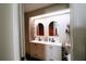 A bathroom with double sinks, decorative wallpaper, and modern fixtures offers convenience and style at 4217 Avanti Cir, New Port Richey, FL 34655