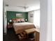 This cozy bedroom features a wooden bed frame, a hunter green accent wall, and abundant natural light at 4217 Avanti Cir, New Port Richey, FL 34655