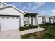 Charming home featuring a well-manicured lawn and inviting entry with cozy outdoor seating at 4217 Avanti Cir, New Port Richey, FL 34655