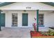 Inviting home entrance showcasing painted brick, complemented by freshly manicured landscaping and a well-lit porch area at 1024 Applewood Dr, Clearwater, FL 33759