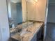Double vanity in the bathroom featuring granite counters and modern fixtures at 25126 Calusa Dr, Punta Gorda, FL 33955