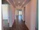 Well-lit hallway with wood floors leading to other rooms in the house at 25126 Calusa Dr, Punta Gorda, FL 33955
