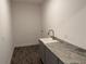 Laundry room featuring wood-look tile floor, granite countertops, and a modern faucet at 25126 Calusa Dr, Punta Gorda, FL 33955