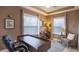 Well-lit home office with a large wooden desk, comfortable chair, and neutral tones at 25126 Calusa Dr, Punta Gorda, FL 33955