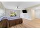 Bedroom with ceiling fan, light walls, wood-look flooring, and backyard view at 3035 Countryside Blvd # 15B, Clearwater, FL 33761