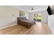 Bedroom with ceiling fan, light walls, wood-look flooring, and view of backyard at 3035 Countryside Blvd # 15B, Clearwater, FL 33761