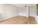 Cozy bedroom with wood floors, closet, white door, and a full-length mirror on the wall at 3035 Countryside Blvd # 15B, Clearwater, FL 33761