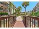 Charming condo exterior showcasing a bridge over a water feature, lush landscaping and palm trees at 3035 Countryside Blvd # 15B, Clearwater, FL 33761