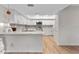 Bright kitchen features white cabinetry, stone countertops, stainless steel appliances, and decorative tile backsplash at 3035 Countryside Blvd # 15B, Clearwater, FL 33761