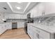 Modern kitchen with stainless steel appliances, granite countertops, white cabinets, and wood-look flooring at 3035 Countryside Blvd # 15B, Clearwater, FL 33761