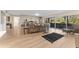 Bright, open living area featuring hardwood floors, neutral walls, a sectional sofa, and sliding glass doors to a patio at 3035 Countryside Blvd # 15B, Clearwater, FL 33761
